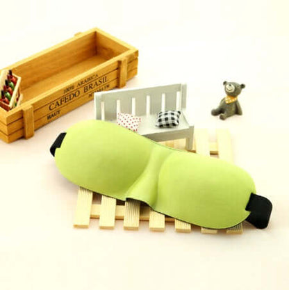 Sleep mask in a soothing green color, designed for ultimate comfort and restful sleep, showcased on a wooden platform.