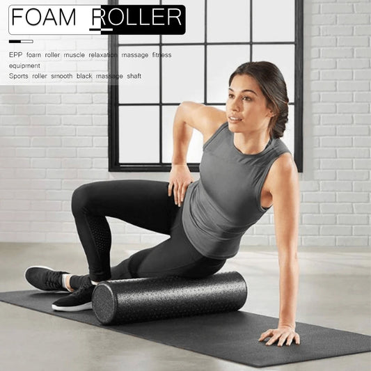 Woman using a foam roller for muscle relaxation in a home setting.