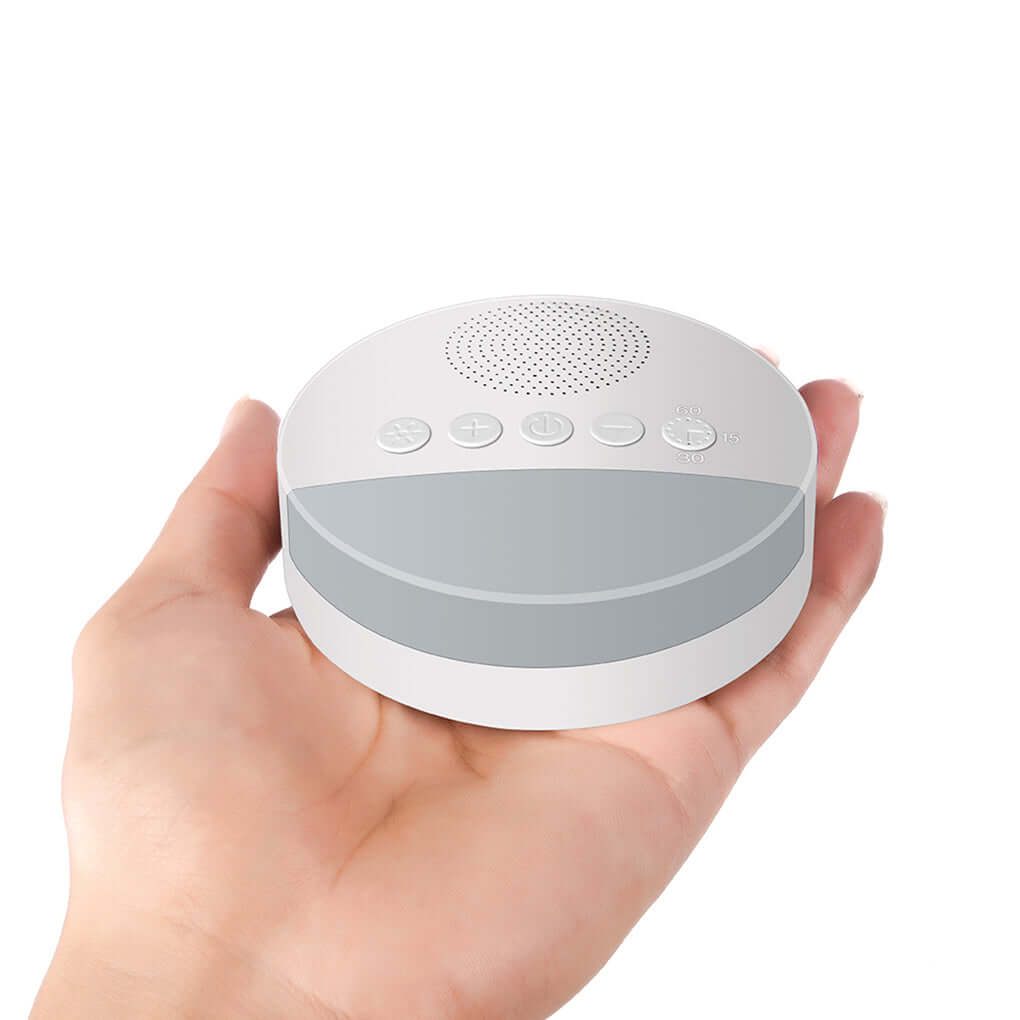 White noise machine in hand, designed to create soothing sounds for relaxation.